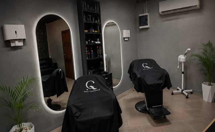Interieur van Quiet Confidence Grooming Lounge — verlichte spiegelstations en stoelen